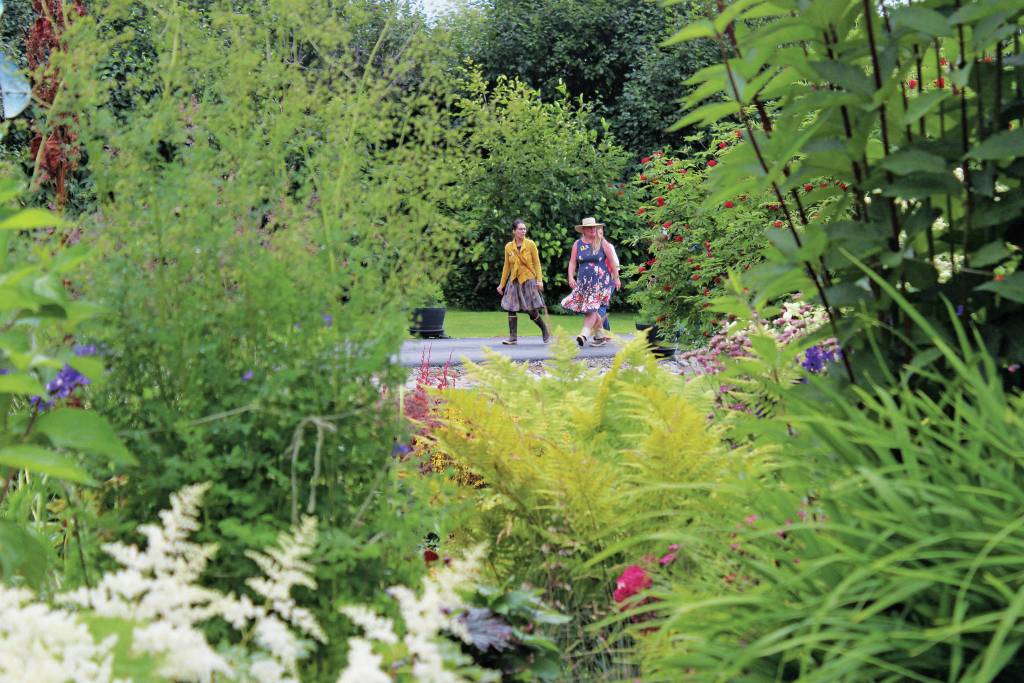 Visitors walk up to an expansive garden off of East End Road, one of five featured in this years Garden Tour on Sunday, July 28, 2019 in and around Homer, Alaska. (Photo by Megan Pacer/Homer News)