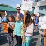 Demonstrators of all ages hold up signs at a rally Sunday, July 28, 2019, against Gov. Mike Dunleavys budget cuts at the Legislative Information Office, Homer, Alaska. (Photo by Michael Armstrong/Homer News).