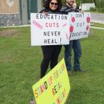 Xochitl Lopez-Ayala, left, and her husband, Don Horton, right, hold signs at a Recall Dunleavy rally held on Aug. 1, 2019, at WKFL Park in Homer, Alaska. (Photo by Michael Armstrong)
