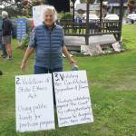 Recall Dunleavy supporter Shelley Gill holds signs listing the reasons to reacll Gov. Mike Dunleavy at a Recall Dunleavy rally held on Aug. 1, 2019, at WKFL Park in Homer, Alaska. (Photo by Michael Armstrong)