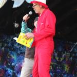 Soldotna resident Daniel Lynch reads from the book One Fish, Two Fish, Red Fish, Blue Fish by Dr. Suess as part of a speech about the importance of protecting salmon habitat on Saturday, Aug. 3, 2019 at Salmonfest in Ninilchik, Alaska. (Photo by Megan Pacer/Homer News)