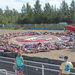 Festival goers prepare to participate in the annual art installation by Homer artist and activist Mavis Muller on Saturday, Aug. 3, 2019 at Salmonfest in Ninilchik, Alaska. Each year, Muller designs an image having to do with salmon and water and makes it out of large pieces of cloth on the rodeo grounds at the Ninilchik Fairgrounds. People attending the festival then surround the image for the final touch while a photo is taken from the air. (Photo by Megan Pacer/Homer News)