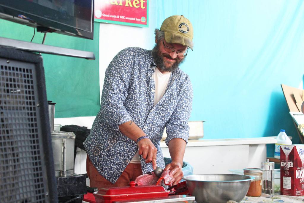 Jeff Lockwood, who hosts the KBBI cooking talkshow Check the Pantry, removes the eggs from a salmon during a food demonstration Saturday, Aug. 3, 2019 at Salmonfest in Ninilchik, Alaska. Lockwood showed festival goers how to use all parts of the fish. (Photo by Megan Pacer/Homer News)