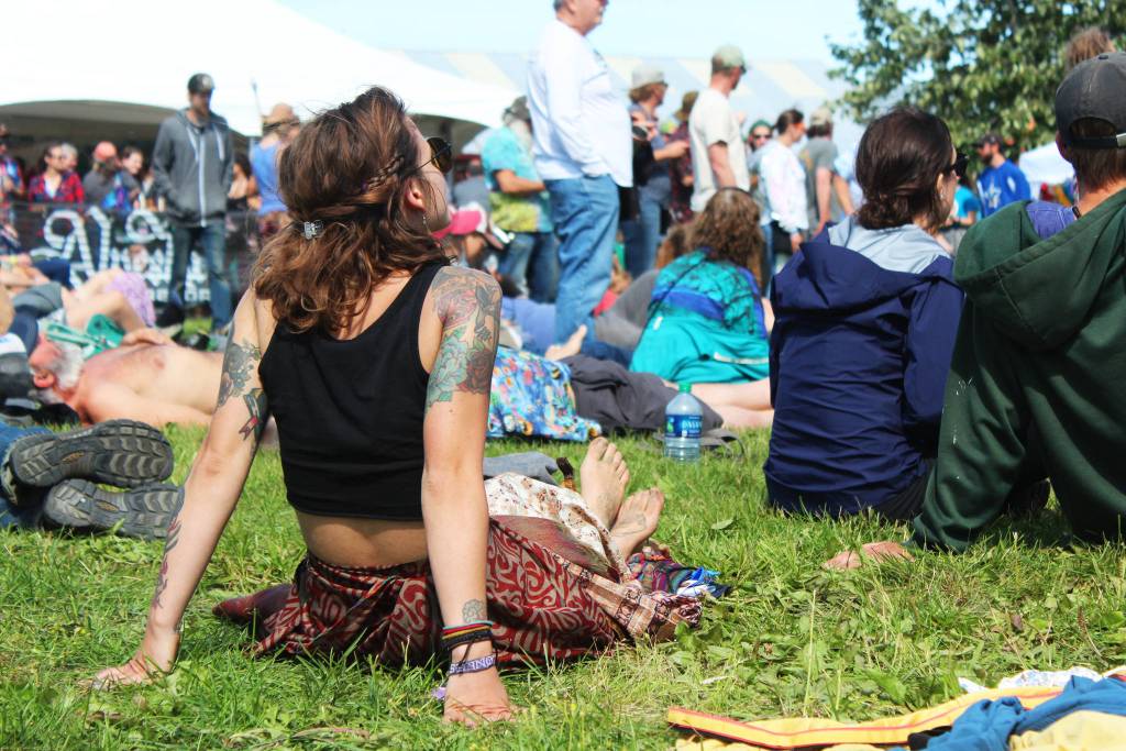 A woman relaxes in the grass while listening to a performance at the Ocean Stage at this years Salmonfest on Friday, Aug. 2, 2019 in Ninilchik, Alaska. (Photo by Megan Pacer/Homer News)