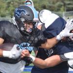 Photo by Jeff Helminiak/Peninsula Clarion                                 Chugiaks Tyler Huffer stiff-arms Soldotnas Hudson Metcalf during a scrimmage Saturday, Aug. 10, at Justin Maile Field in Soldotna.