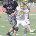 Photo by Jeff Helminiak/Peninsula Clarion                                 Nikiskis Mason Payne runs against Sewards Steven Harshman in a scrimmage Saturday, Aug. 10, at the Ed Hollier Field in Kenai.