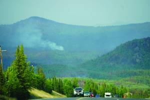 Photo by Michael Armstrong/Homer News                                 A plume of smoke rises from the Swan Lake fire area as vehicles head south on the Sterling Highway on July 18, near Skilak Lake between Sterling and Cooper Landing.