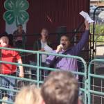 brian mazurek/peninsula clarion                                Auctioneers Andy Kriner, left, and Rayne, Reynolds, right, celebrate a successful sale during the 4H Junior Market Livestock Auction at the Kenai Peninsula Fair on Saturday at the fairgrounds in Ninilchik. (Photo by Brian Mazurek/Peninsula Clarion)