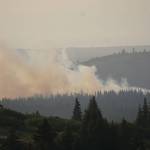 A helicopter flies over the North Fork fire as it burns near the south end of the North Fork Road on Sunday evening, Aug. 18, 2019, near Homer, Alaska, as seen from Diamond Ridge Road. (Photo by Michael Armstrong/Homer News)