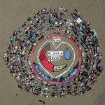 Salmonfest attendees participate in the annual art installation by Homer artist and activist Mavis Muller on Saturday, Aug. 3, 2019 at Salmonfest in Ninilchik, Alaska. The message of this years art piece was S.O.S. or Save our salmon. (Photo by Brandon Hill)