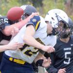 Nikiskis Caleb Weeks, Drew Handley and Mason Payne sack Homer quarterback Anthony Kalugin and force a fumble Friday, Aug. 30, 2019, at Nikiski High School in Nikiski, Alaska. (Photo by Jeff Helminiak/Peninsula Clarion)