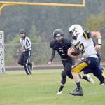 Homer quarterback Anthony Kalugin eludes Nikiskis Sam Berry to score a touchdown Friday, Aug. 30, 2019, at Nikiski High School in Nikiski, Alaska. (Photo by Jeff Helminiak/Peninsula Clarion)