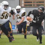 Nikiski quarterback Noah LItke scrambles away from Homers Zack Condon and Sean Pilant on Friday, Aug. 30, 2019, at Nikiski High School in Nikiski, Alaska. (Photo by Jeff Helminiak/Peninsula Clarion)