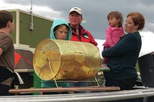 Jack and Ben Engebretsen, sons of Bay Weld general manager Erik Engebretsen, draw the winning ticket for the Homer Chamber of Commerce and Visitor Center Bay Well skiff contest as chamber board secretary Kari Dendurent, center, and chamber executive director Debbie Speakman, with daughter Alice, watch. The drawing was held on Sept. 2, 2019, at Grace Ridge Brewery in Homer, Alaska. (Photo provided)