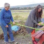 Peggy Gavillot, left, and Lora Wilke, right weave leaves for the 16th annual Burning Basket, Radiate, on Tuesday, Sept. 10, 2019, at Mariner Park on the Homer Spit in Homer, Alaska. (Photo by Michael Armstrong/Homer News)
