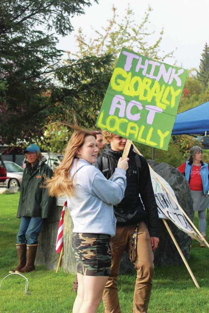A student holds up a sign reading Think globally act locally during the Homer Youth Climate Strike on Friday, Sept. 20, 2019 at Wisdom, Knowledge, Faith and Love Park in Homer, Alaska. (Photo by Megan Pacer/Homer News)
