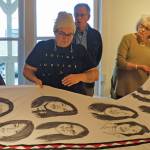 Amber Webb, center, discusses her kuspuk at the opening of the Kuspuk/Qaspeq/Atikluk show on Oct. 5, 2019, at Bunnell Street Arts Center in Homer, Alaska. The kuspuk shows faces of missing or murdered indigenous women. (Photo by Michael Armstrong/Homer News)