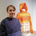 Erin Gingrich stands by her kuspuk at the opening of the Kuspuk/Qaspeq/Atikluk show on Oct. 5, 2019, at Bunnell Street Arts Center in Homer, Alaska. Her work includes printed fabric using designs from her sculptures. (Photo by Michael Armstrong/Homer News)