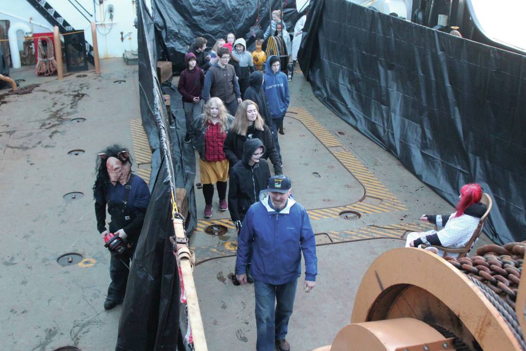 A member of the Haunted Hickory waits around the corner to scare a group of guests at the haunted house set up on the US Coast Guard Hickory on Friday, Oct. 25, 2019 on the vessel at the harbor in Homer, Alaska. (Photo by Megan Pacer/Homer News)