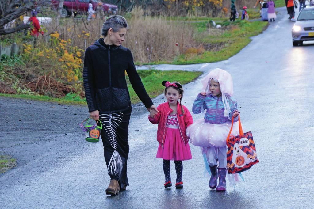 Carla Cope, left, leads ?? and ?? for Halloween trick-or-treating on Bayview Avenue on Oct. 31, 2019, in Homer, Alaska. (Photo by Michael Armstrong/Homer News)