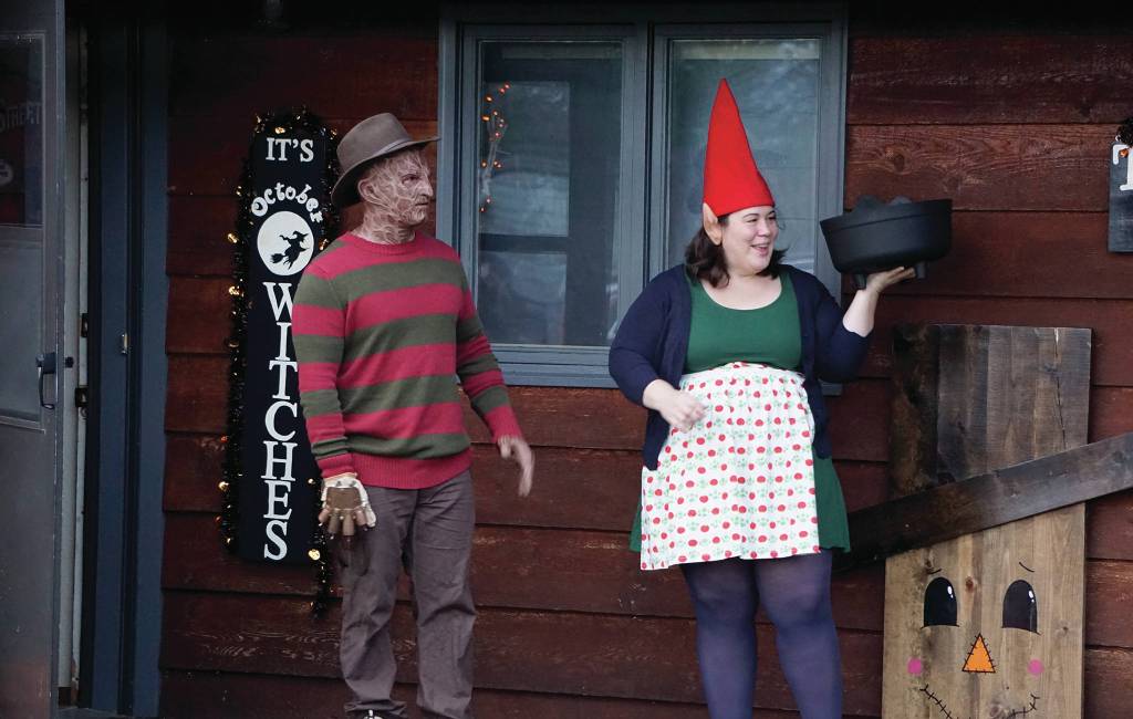 Sean Perry, left, and Eve Dickman,right, hand out candy at the home of Sean and Sandra Perry for Halloween on Oct. 31, 2019, in Homer, Alaska. (Photo by Michael Armstrong/Homer News)