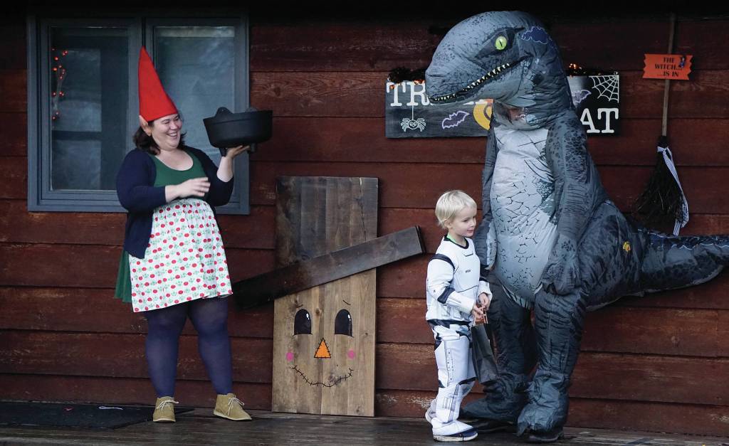 Eve Dickman hands out candy at the home of Sean and Sandra Perry for Halloween on Oct. 31, 2019, in Homer, Alaska. (Photo by Michael Armstrong/Homer News)