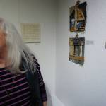 Ann-Margret Wimmerstedt stands by two of her works in the 10x10 show at Bunnell Street Arts Center that opened on Nov. 8, 2019, in Homer, Alaska. (Photo by Michael Armstrong/Homer News)