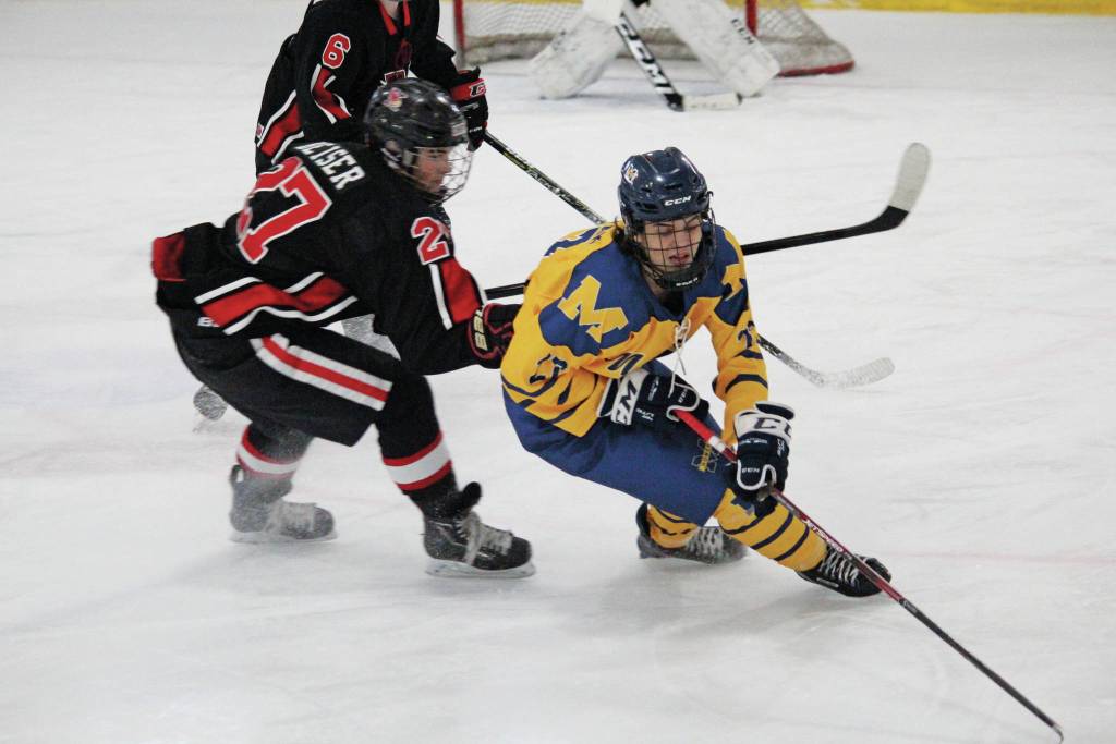 Homers Isaiah Nevak maneuvers the puck away from Kenais Cooper Stock during a Saturday, Nov. 23, 2019 hockey game at Kevin Bell Arena in Homer, Alaska. (Photo by Megan Pacer/Homer News)
