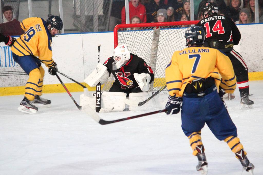 Homers Alden Ross (left) tries to get the puck past Kenai goalie Thomas Baker during a Saturday, Nov. 23, 2019 hockey game at Kevin Bell Arena in Homer, Alaska. (Photo by Megan Pacer/Homer News)