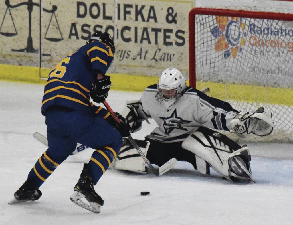 Homers Ethan Pitzman challenges Soldotna goalie Corbin Wirz at the net Friday at the Soldotna Regional Sports Complex in Soldotna. (Photo by Joey Klecka/Peninsula Clarion)