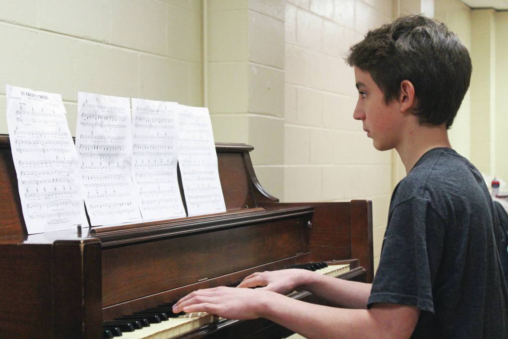 Lion Trejo, 14, plays piano music for people attending a free community Thanksgiving meal Thursday, Nov. 28, 2019 at Homer United Methodist Church in Homer, Alaska. (Photo by Megan Pacer/Homer News)