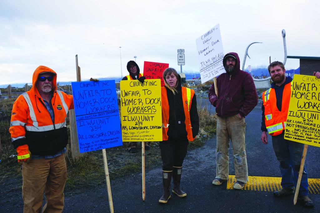 Homer longshore workers picket on the Homer Spit by Freight Dock Road on Tuesday, Dec. 17, 2019, in Homer, Alaska. They were part of a group of about 20 Alaska International Longshore and Warehouse Union members or supporters hold an area standards picket in response to Chumleys Inc. use of workers to load a sulfur hauler ship the ILWU alleges are paid substandard wages. From left to right, are Grant Lane, Paul Gregoire, Carley Conemac, Jeff Allmendinger and Brian Dingman. (Photo by Michael Armstrong/Homer News)