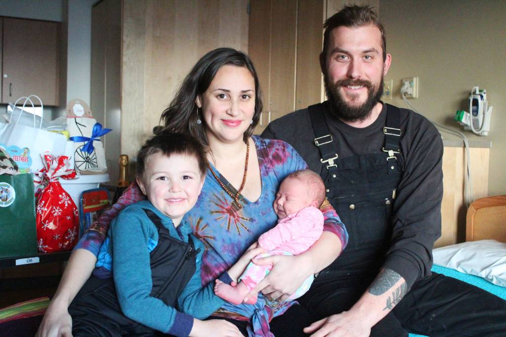 From left to right: Juneau Bettinger, Allyse Bettinger, Sequoia Bettinger and Owen Bettinger rest on a bed in front of a tray of gifts Tuesday, Jan. 8, 2019 at South Peninsula Hospital in Homer, Alaska. The Bettingers celebrated the arrival of their newest family members on Jan. 1. Sequoia was Homers first baby born in the new year. (Photo by Megan Pacer/Homer News)