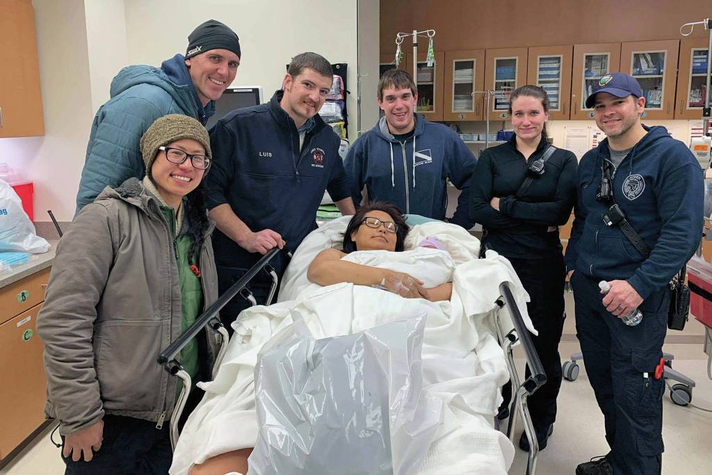 Members of the Homer Volunteer Fire Department pose with new parents Stephanie Cozadd-Pearson (center, foreground) and Jasiah Carlson (third from the right) after helping deliver the first baby born in Homer, Alaska in 2020, Ariyana Carlson. Cozadd-Pearson delivered at home on Jan. 2, 2020 with the help of the medics when she realized she and Carlson would not make it to the hospital in time. (Photo courtesy Assistant Fire Chief Dan Miotke)