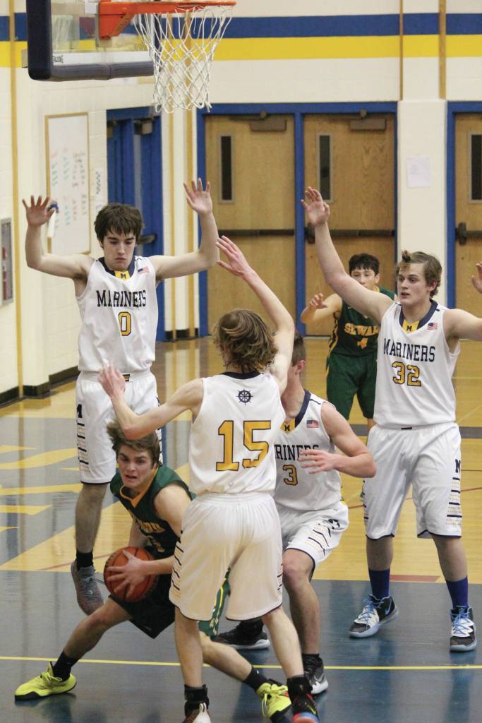 Sewards Sam Koster looks for a way to go among a horde of Mariners during a Saturday, Jan. 11, 2020 basketball game between the two teams at the Alice Witte Gymnasium in Homer, Alaska. (Photo by Megan Pacer/Homer News)