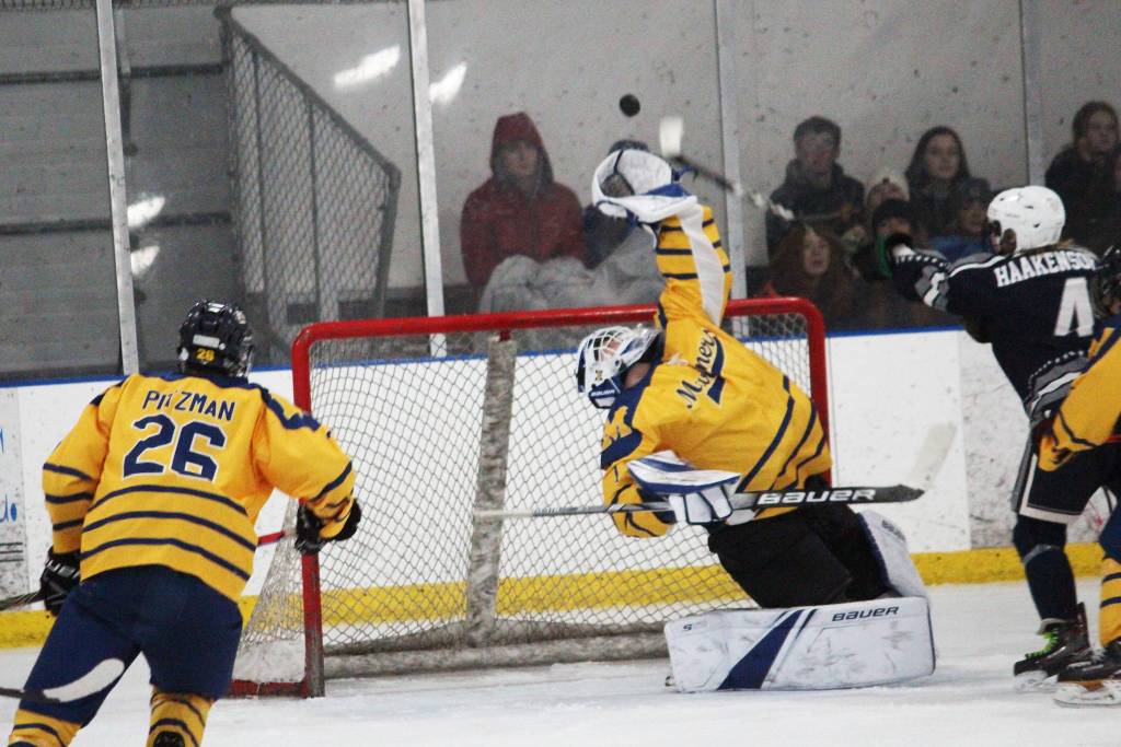 Homer goalkeeper Keegan Strong reaches to make a save during a Wednesday, Jan. 15, 2020 hockey game against Soldotna High School at the Kevin Bell Arena in Homer, Alaska. (Photo by Megan Pacer/Homer News)