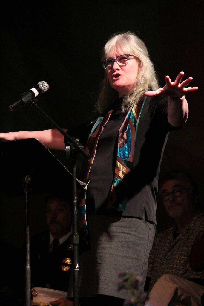 Marie McCarty speaks about Gary Thomas, a Homer man killed last week in a water heater explosion, during a Sunday, Jan. 19, 2020 memorial for him at Homer Mariner Theatre at Homer High School in Homer, Alaska. Thomas often volunteered as an auctioneer for the Kachemak Heritage Land Trust and other organizations having live auctions. (Photo by Megan Pacer/Homer News)