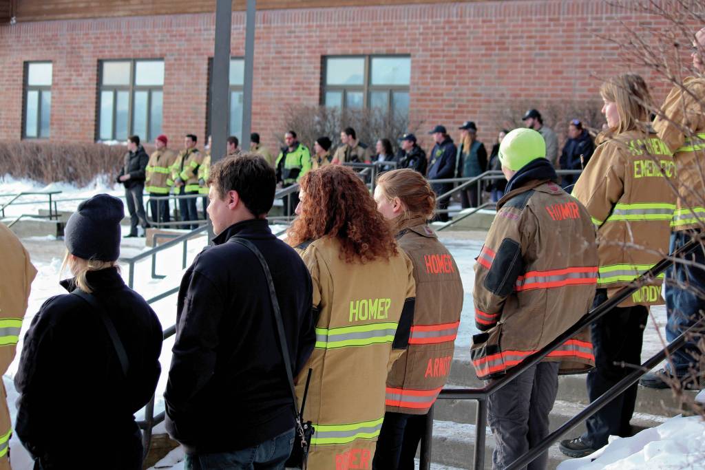 Firefighters and medics lines the steps to Homer High School before a memorial for Gary Thomas on Sunday, Jan.19, 2020 in Homer, Alaska. Thomas, a community advocate and volunteer firefighter for more than 40 years, was found dead this month after a water heater explosion at a home out East End Road. (Photo by Megan Pacer/Homer News)