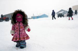 Gregory Bull | Associated Press                                A girl waits for her mother Sunday in Toksook Bay, Alaska.