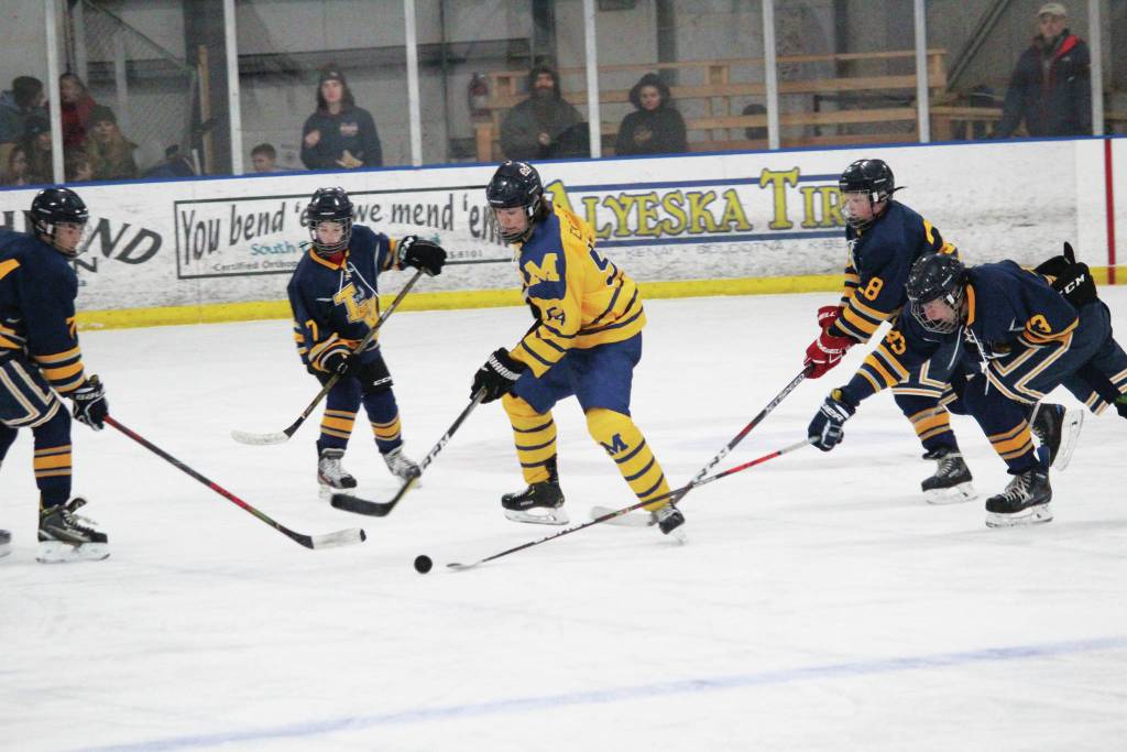 Homers Phinny Weston tries to control the puck among a group of Tri-Valley School players during a Thursday, Jan. 30, 2020 hockey game at the Kevin Bell Arena in Homer, Alaska. (Photo by Megan Pacer/Homer News)