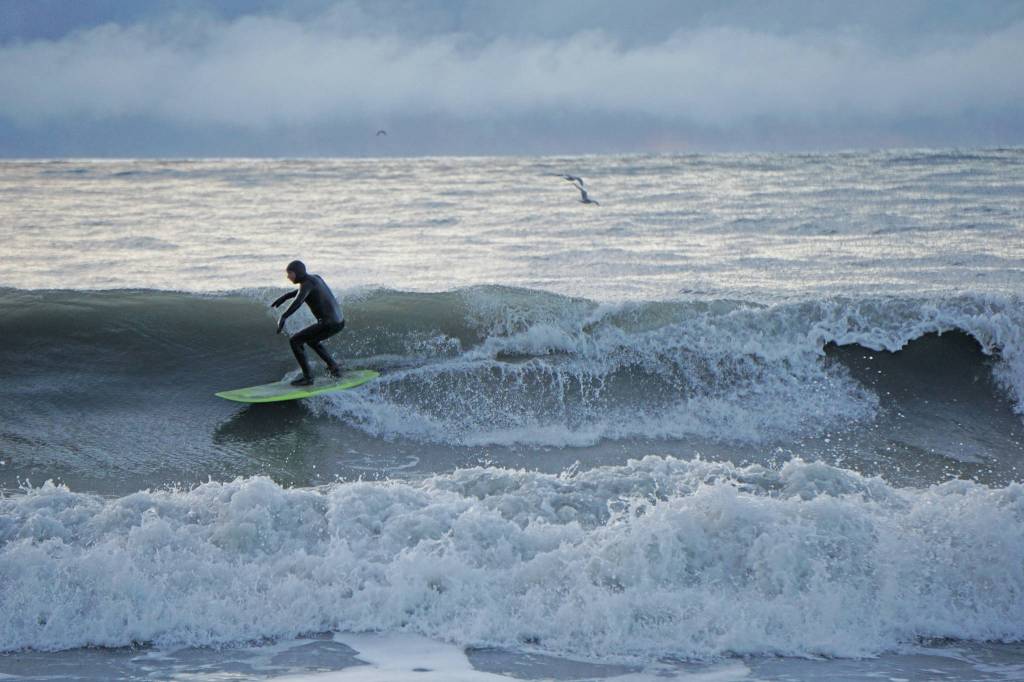 A man surfs off the Homer Spit on Thursday afternoon, Jan. 30, 2020, in Homer, Alaska. (Photo by MIchael Armstrong/Homer News)