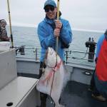 Øisten Stokke Berget of Trondheim, Norway, holds a halibut he caught while fishing on the North Country Charters fishing boat Irish on July 16, 2017, near Homer, Alaska. (Photo by Michael Armstrong/Homer News file photo)