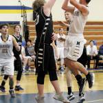 Homers Clayton Beachy jumps to take a shot while Nikiskis Drew Handley reaching to block him during a Friday, Feb. 28, 2020 basketball game in the Alice Witte Gymnasium in Homer, Alaska. (Photo by Megan Pacer/Homer News)
