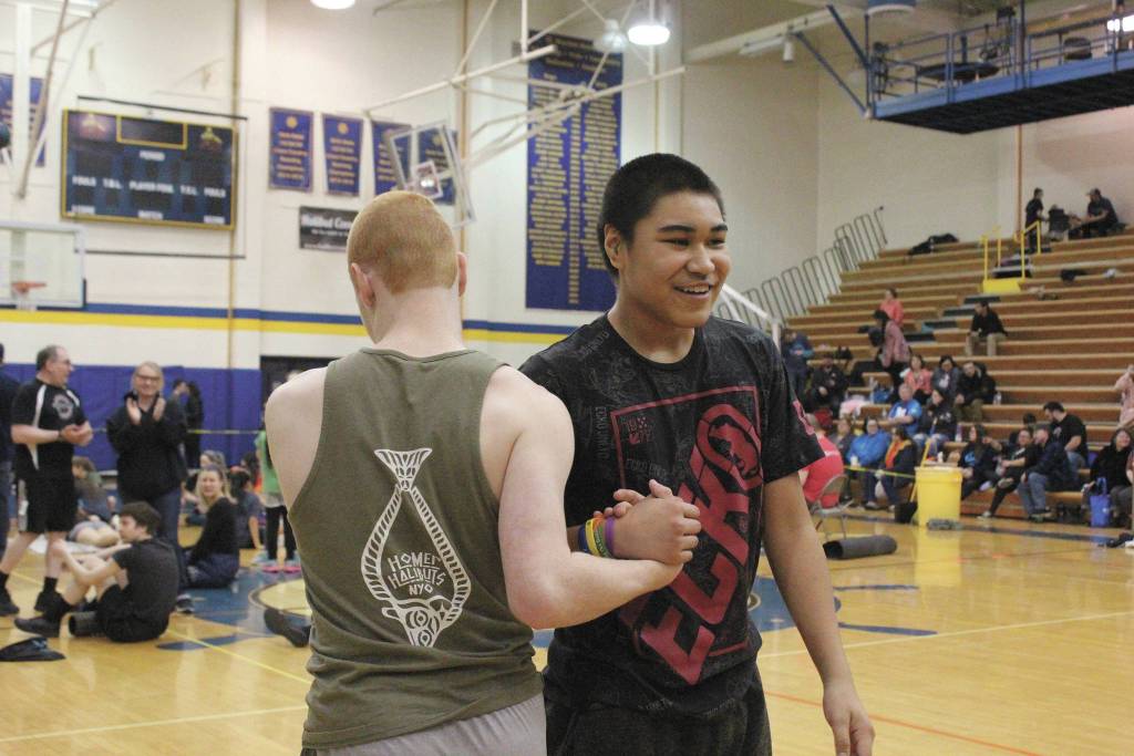 Homers Elijah Gordon, left, congratulates James Mishakoff of Tebughna School in Tyonek after his turn during the one-foot high kick event Saturday, March 7, 2020 at the Kachemak Bay Traditional Games, a Native Youth Olympics invitational, at Homer High School in Homer, Alaska. (Photo by Megan Pacer/Homer News)