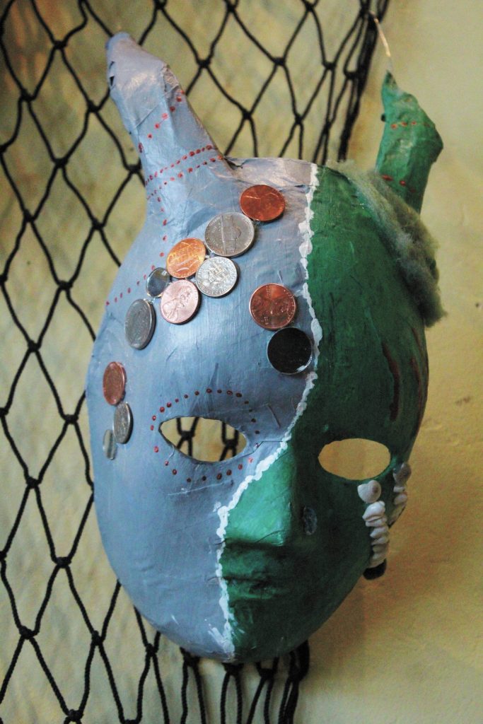 A decorative mask made by a Fireweed Academy student hangs in K-Bay Caffe during an art exhibit opening on Thursday, March 5, 2020 in Homer, Alaska. The masks were made with the help of Artist in the Schools participant Gail Baker. (Photo by Megan Pacer/Homer News)