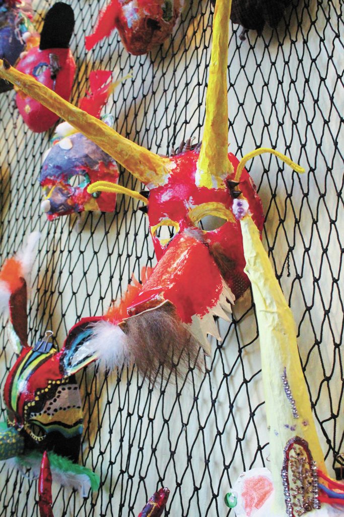 A decorative mask made by a Fireweed Academy student hangs in K-Bay Caffe during an art exhibit opening on Thursday, March 5, 2020 in Homer, Alaska. The masks were made with the help of Artist in the Schools participant Gail Baker. (Photo by Megan Pacer/Homer News)