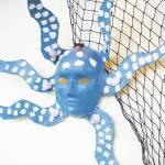 A decorative mask hangs in K-Bay Caffe as part of the art exhibit opening for Fireweed Academy students on Thursday, March 5, 2020 in Homer, Alaska, showcasing the work they did with Artist in the Schools Program participant Gail Baker. (Photo by Megan Pacer/Homer News)