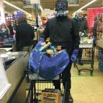 Bjørn Olson shops in protective gear for people who cant go to the store themselves on March 23, 2020 at Safeway in Homer, Alaska. Olson volunteers each Monday to shop for the elderly, those at increased risk of contracting the novel coronavirus or those self isolating at home due to the spread of the illness it causes, COVID-19. (Photo by Megan Pacer/Homer News)