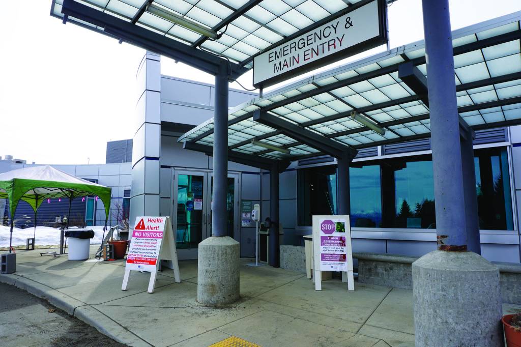 Signs on Saturday, March 28, 2020, at the main entrance to South Peninsula Hospital in Homer, Alaska, warn visitors not to enter until they have been met by hospital staff. (Photo by Michael Armstrong/Homer News)