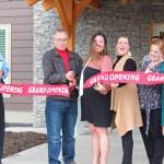 Aspen Hotel chain Owner George Swift cuts a ribbon officially opening the most recent building in Homer, Alaska, during a grand opening ceremony on May 29, 2019. (Photo by Megan Pacer/Homer News)